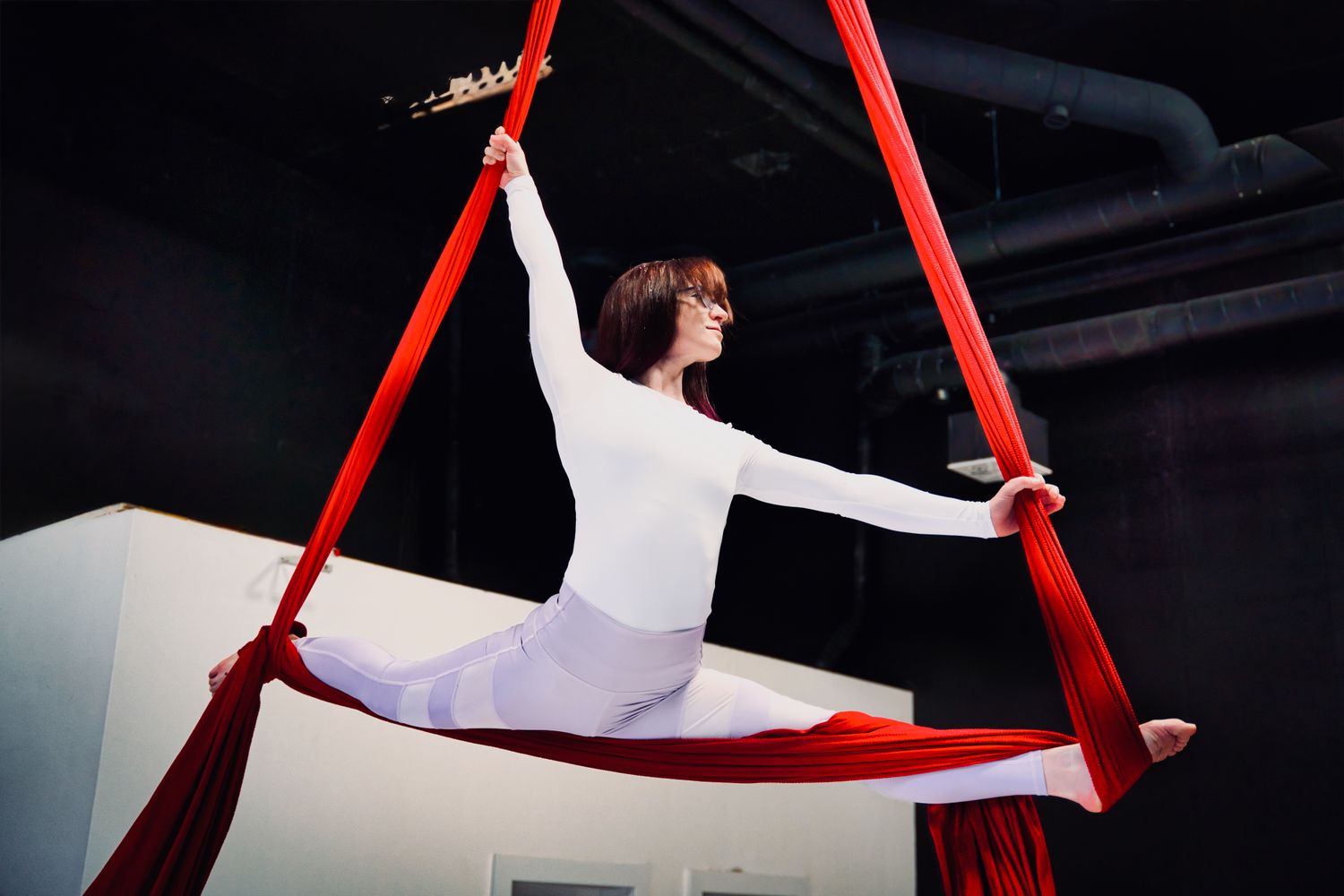 Artiste en grand écart sur un tissu aérien