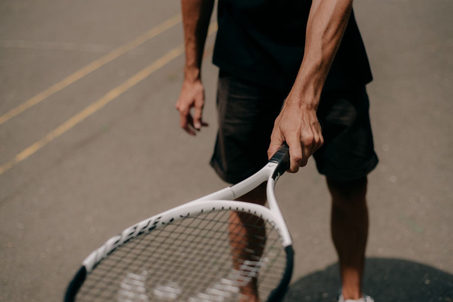 Main serrée sur le manche d'une raquette de tennis